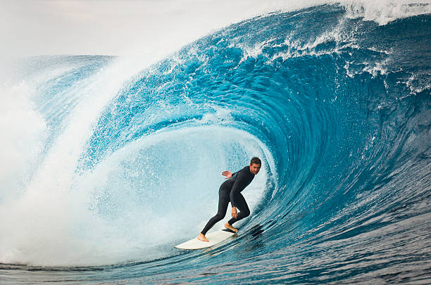 a male surfer cruising along a huge wave. a male surfer cruising along a huge wave.